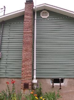 Exterior radon vent pipe and fan installed on a home